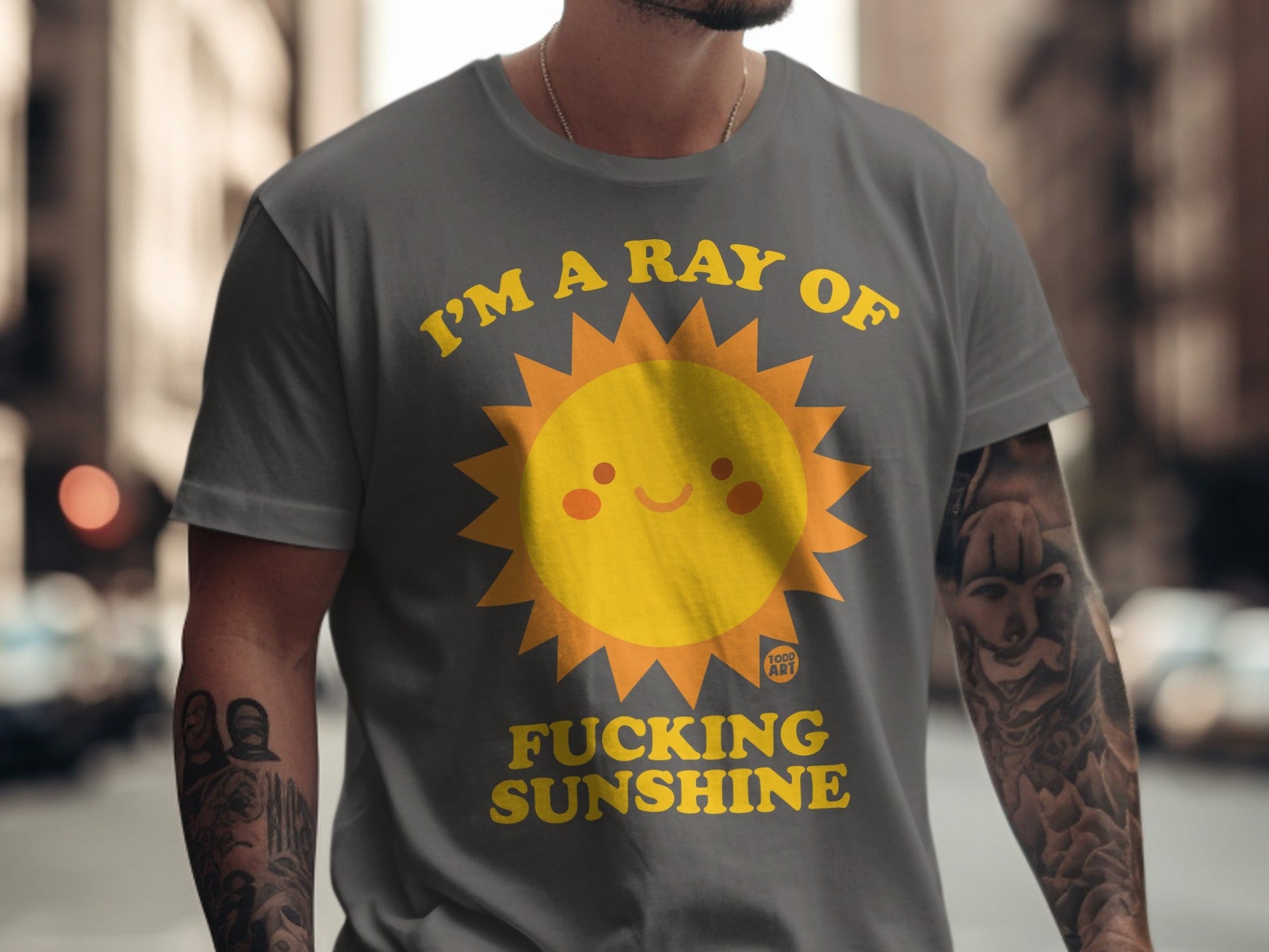 T-shirt with a smiling sun graphic and "I'M A RAY OF FUCKING SUNSHINE" text.