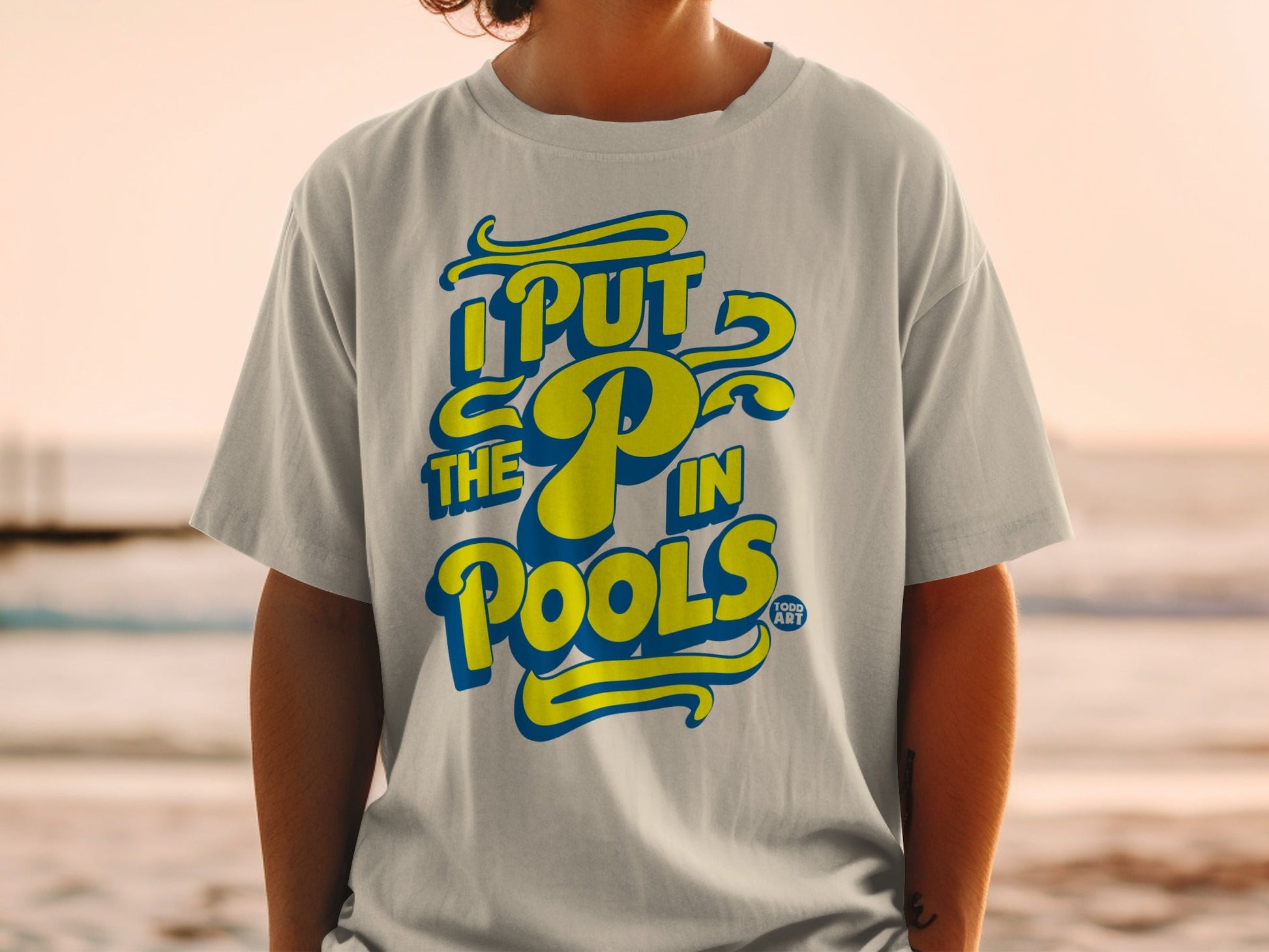 Yellow and blue text on a t-shirt reads "I PUT THE P IN POOLS".