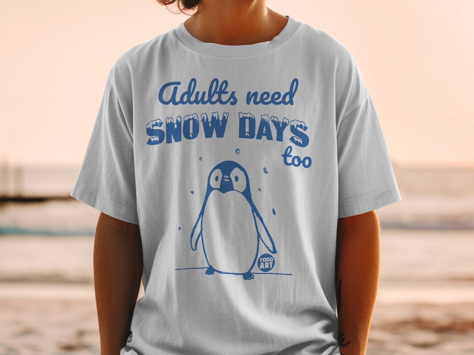 T-shirt with blue penguin graphic and "Adults need Snow Days too" text.