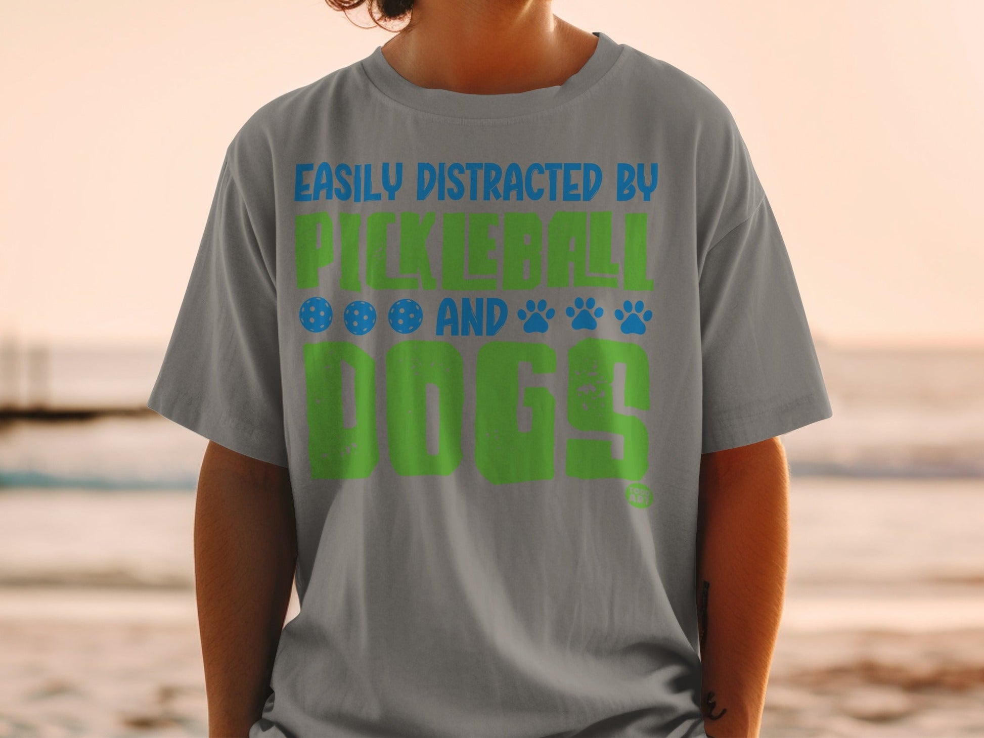 Gray t-shirt with "Easily Distracted by Pickleball and Dogs" in green and blue.