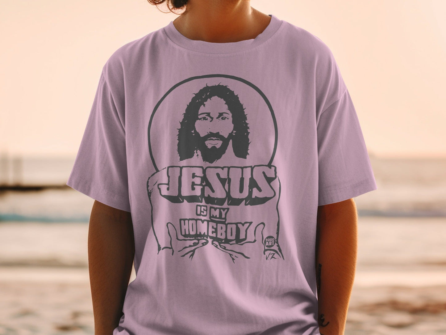 Purple t-shirt with Jesus is My Homeboy graphic and circular design.