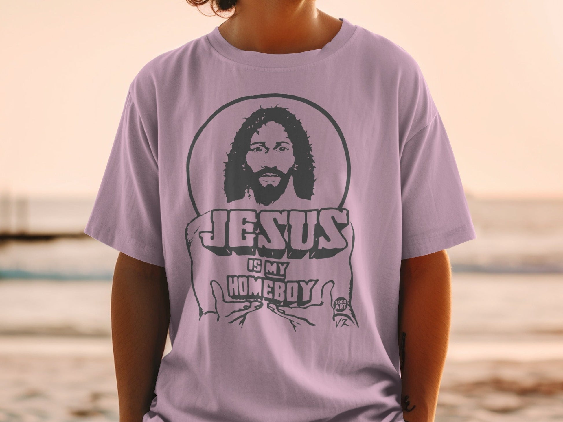 Purple t-shirt with Jesus is My Homeboy graphic and circular design.