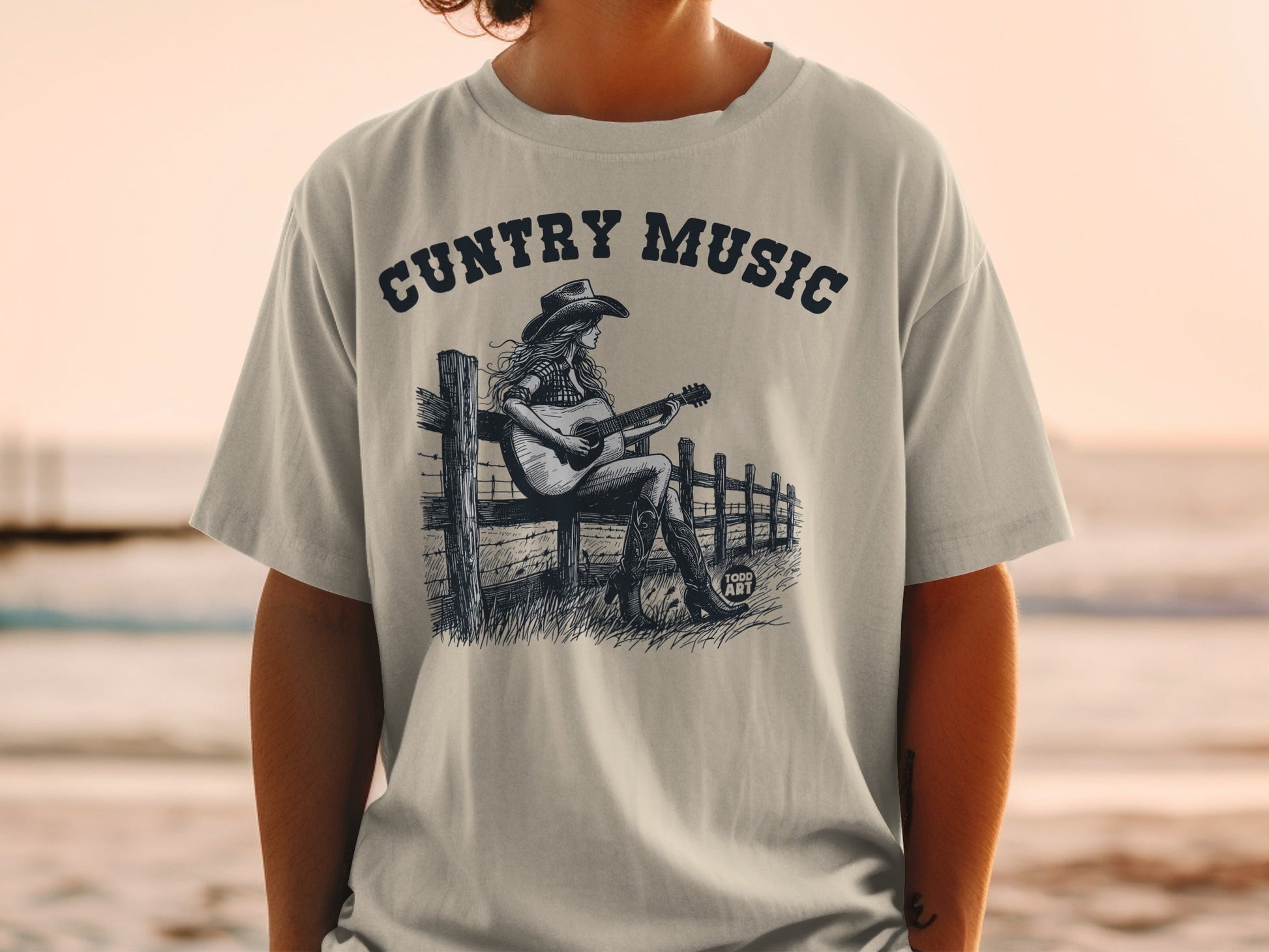 Country Music graphic tee with a woman playing guitar on a fence.