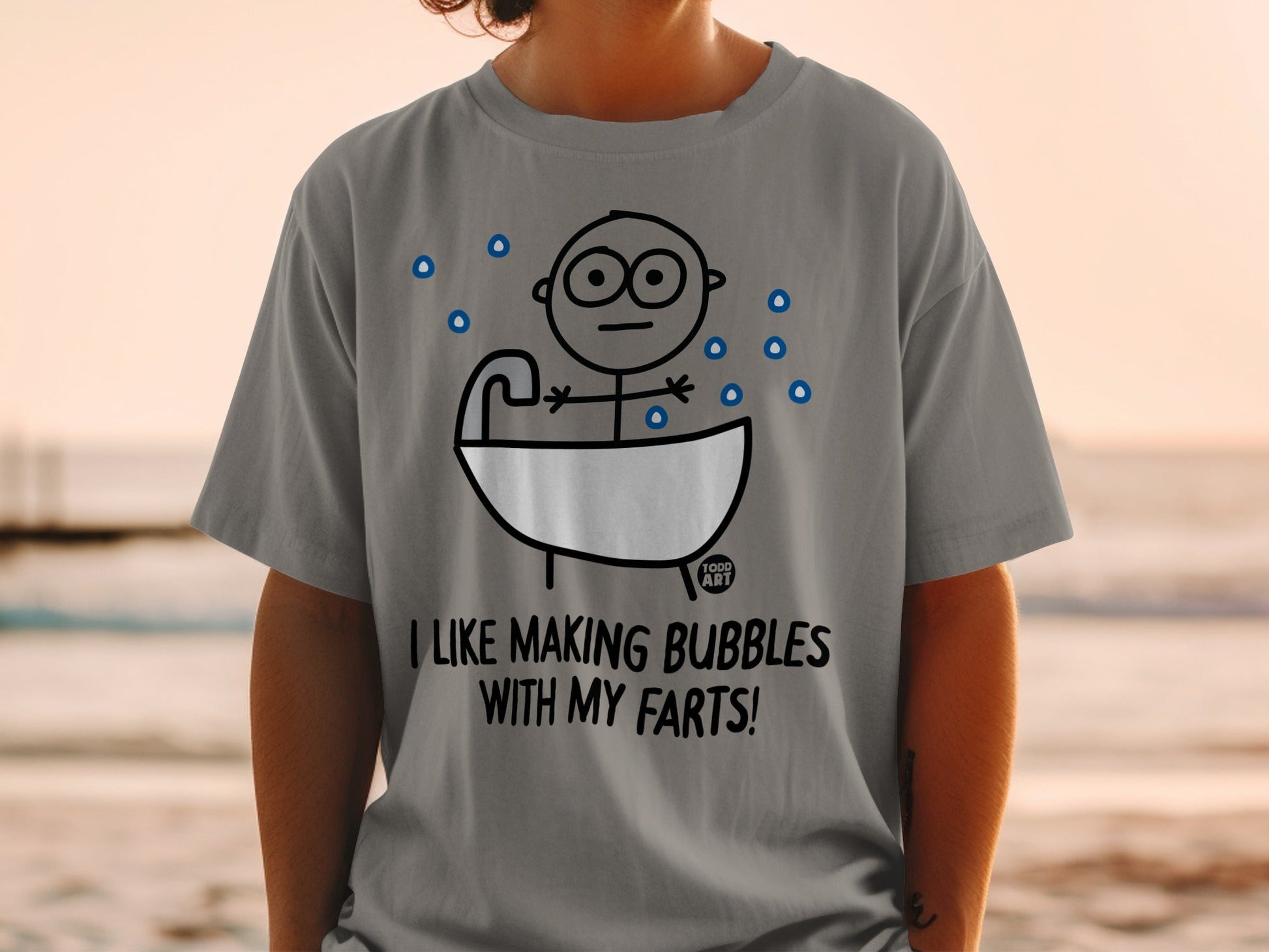 Gray t-shirt with cartoon character in a bathtub and text "I LIKE MAKING BUBBLES WITH MY FARTS!".