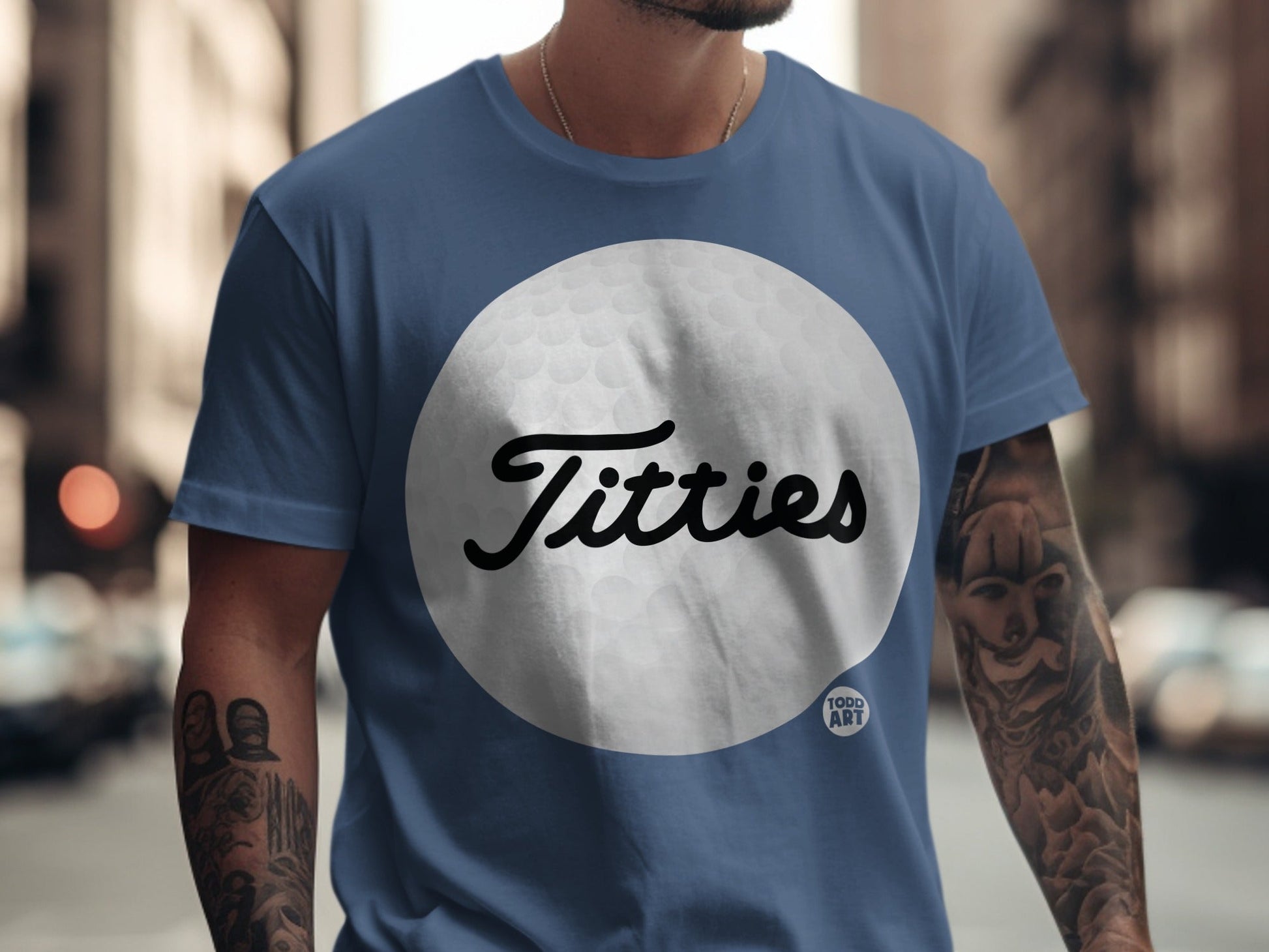Blue t-shirt with "Titties" in script over a golf ball graphic.