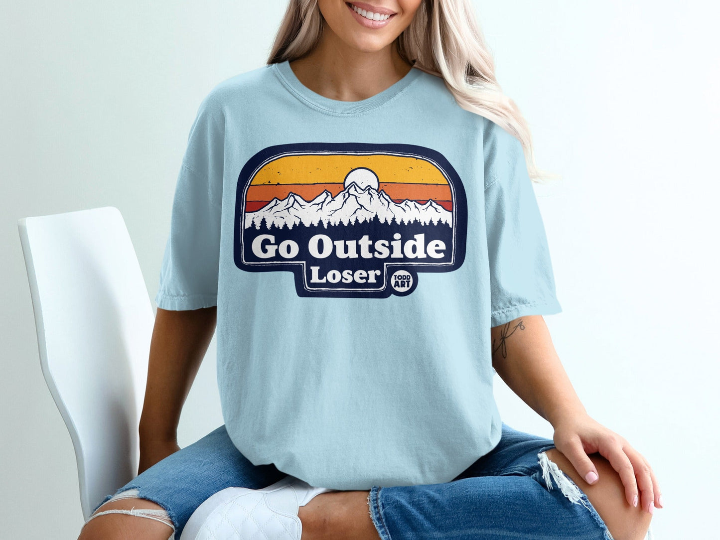 Light blue t-shirt with "Go Outside Loser" mountain sunset graphic.