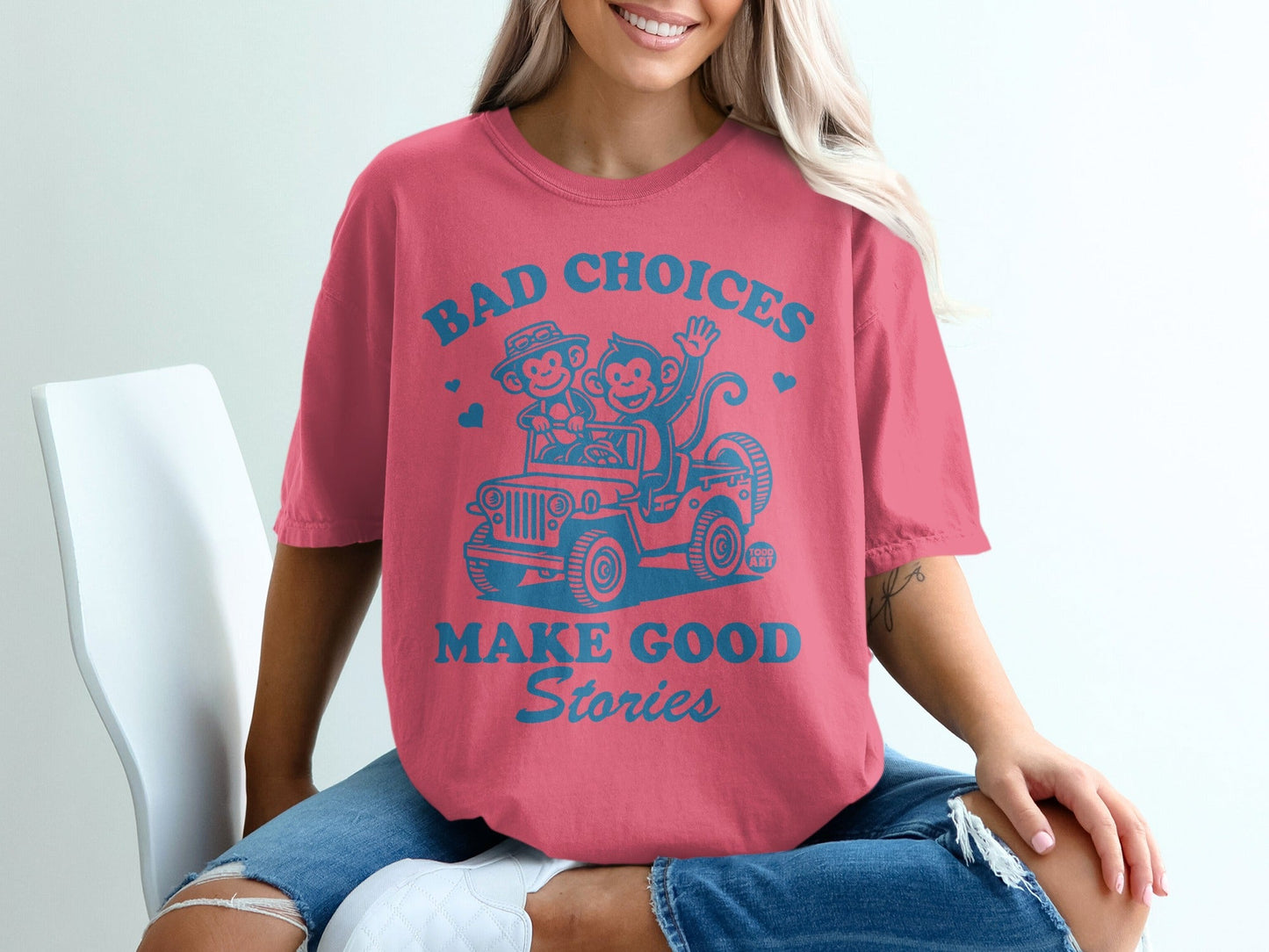 Coral t-shirt with cartoon monkey and bear driving a jeep, text reads "BAD CHOICES MAKE GOOD STORIES".