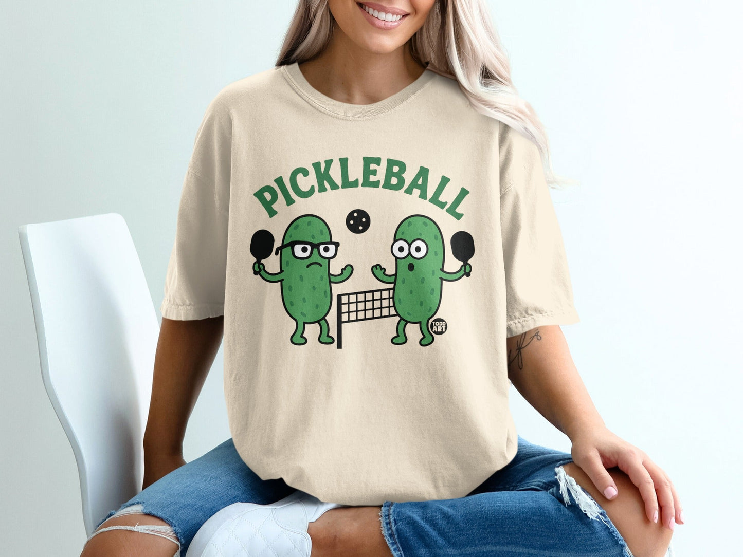 Cartoon pickles playing pickleball on a net, wearing glasses.