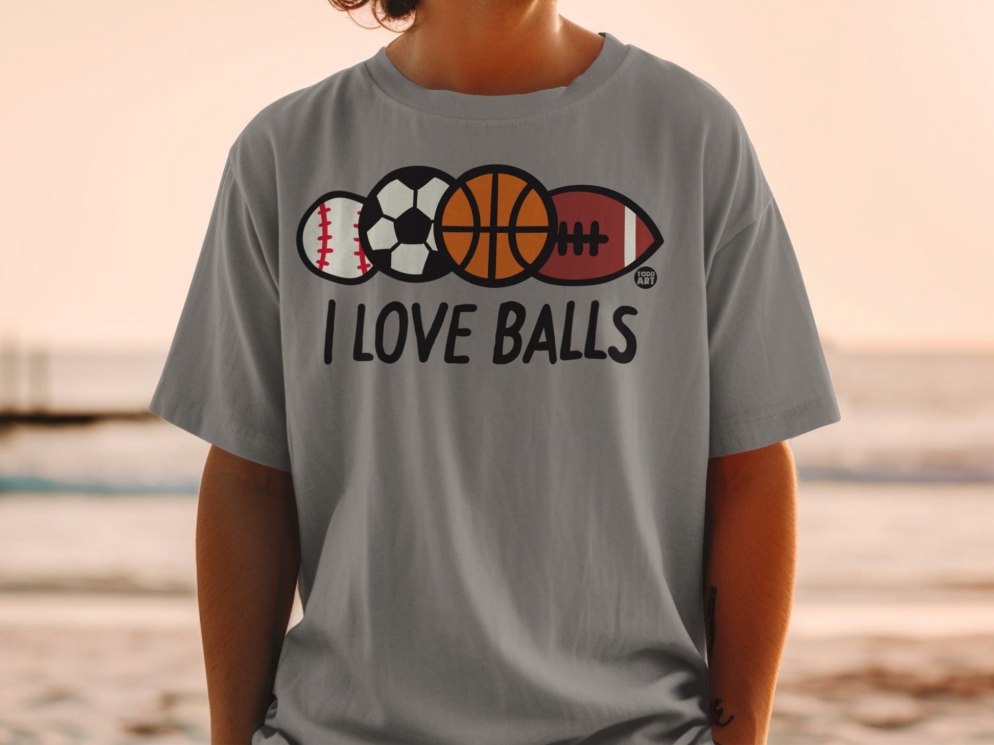Gray t-shirt with "I LOVE BALLS" text and baseball, basketball, football, and rugby balls.