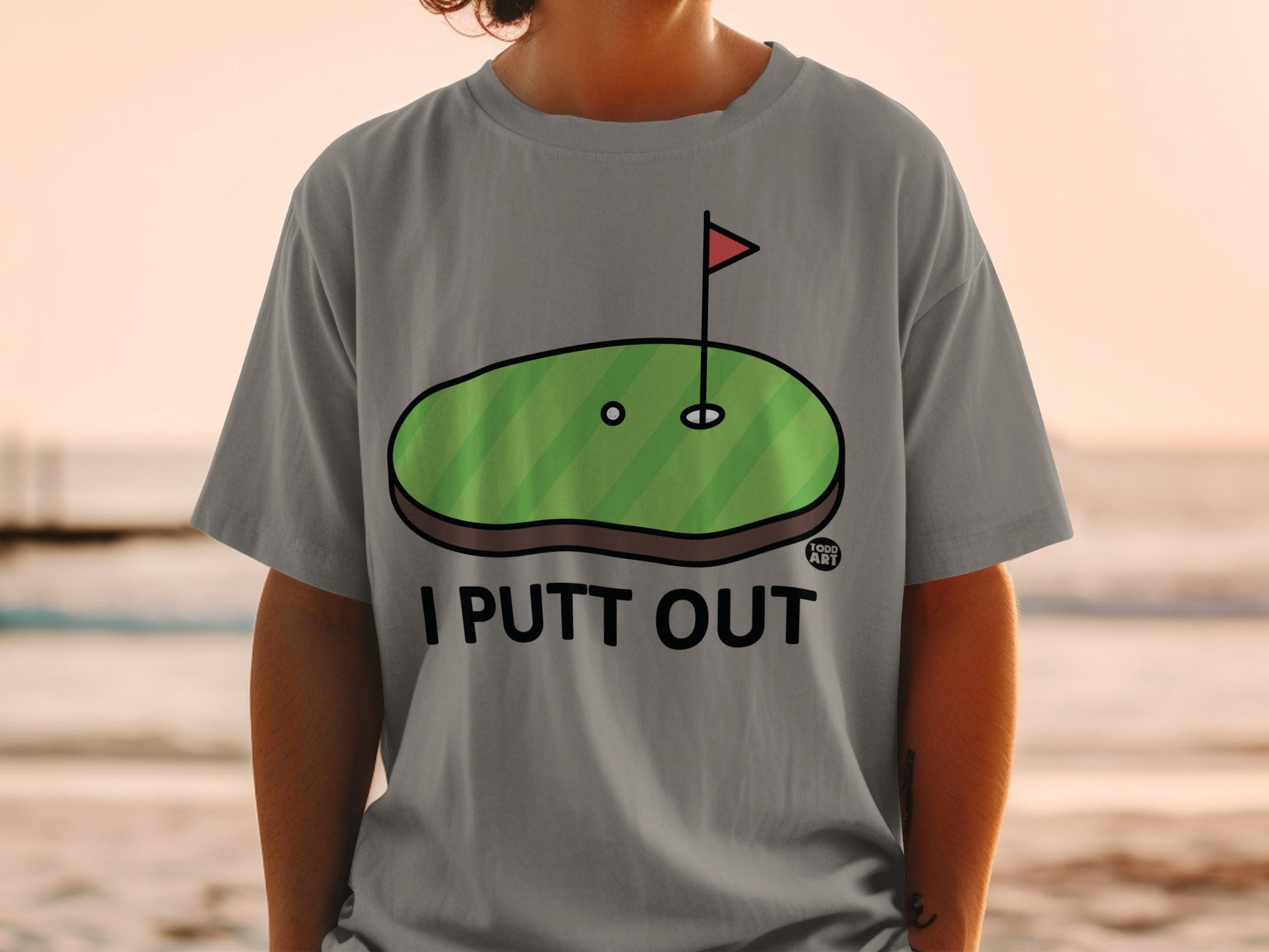 Grey t-shirt with "I PUTT OUT" and a golf hole graphic.