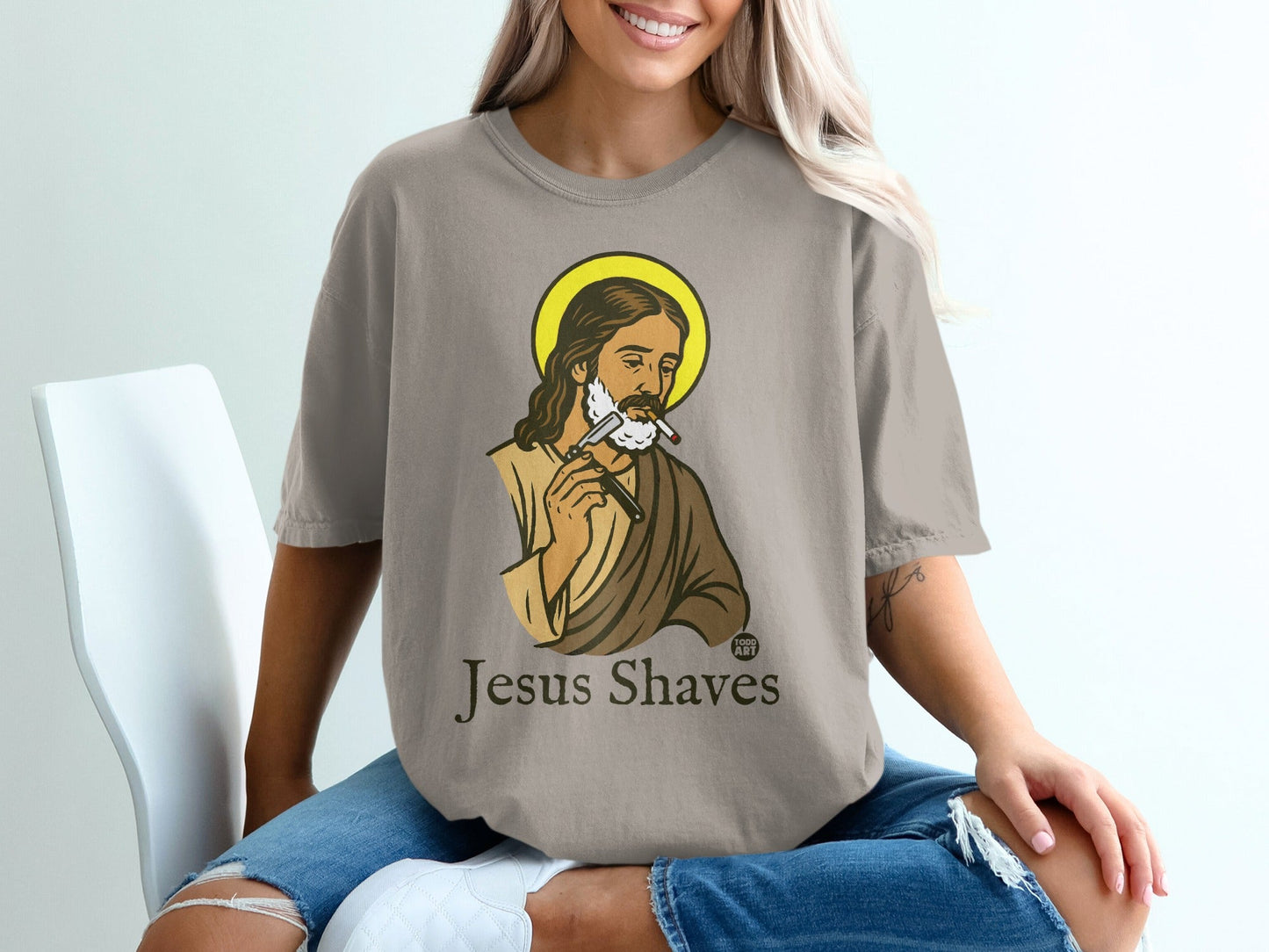 Jesus Shaves graphic on a taupe t-shirt.