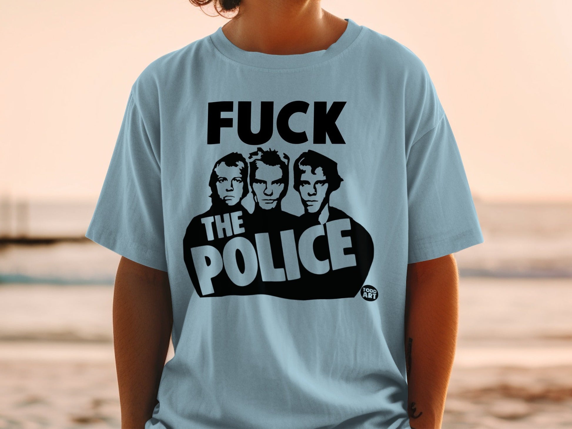 Light blue t-shirt featuring the band "The Police" in black stylized lettering.