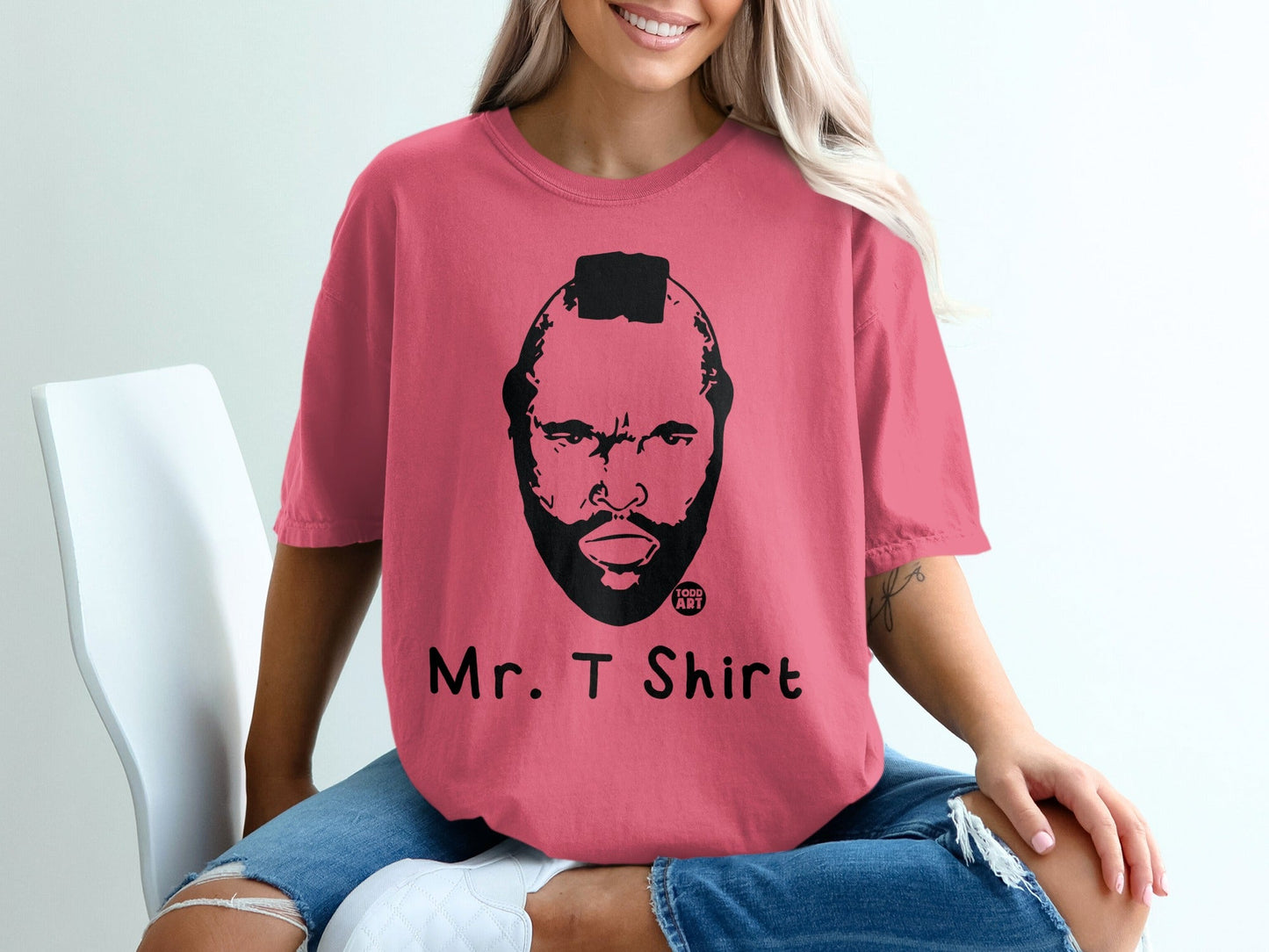 Pink t-shirt featuring a black and white illustration of Mr. T's face with text "Mr. T Shirt".