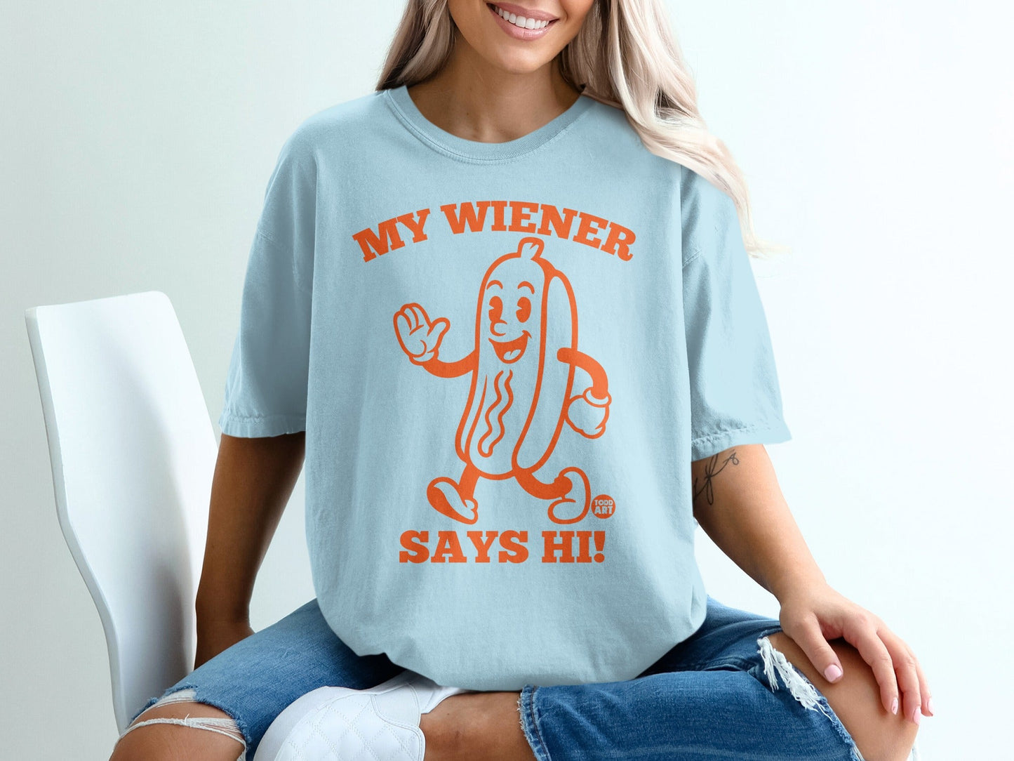 Light blue t-shirt with cartoon hot dog saying "MY WIENER SAYS HI!".