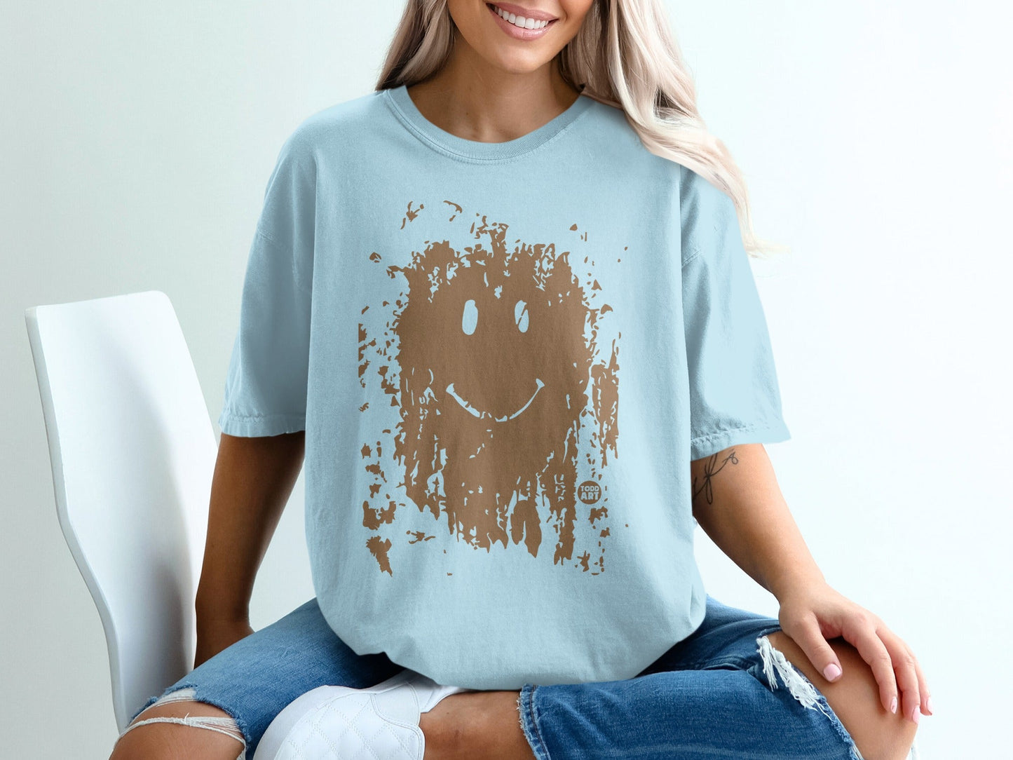 Light blue t-shirt with distressed brown smiley face graphic.