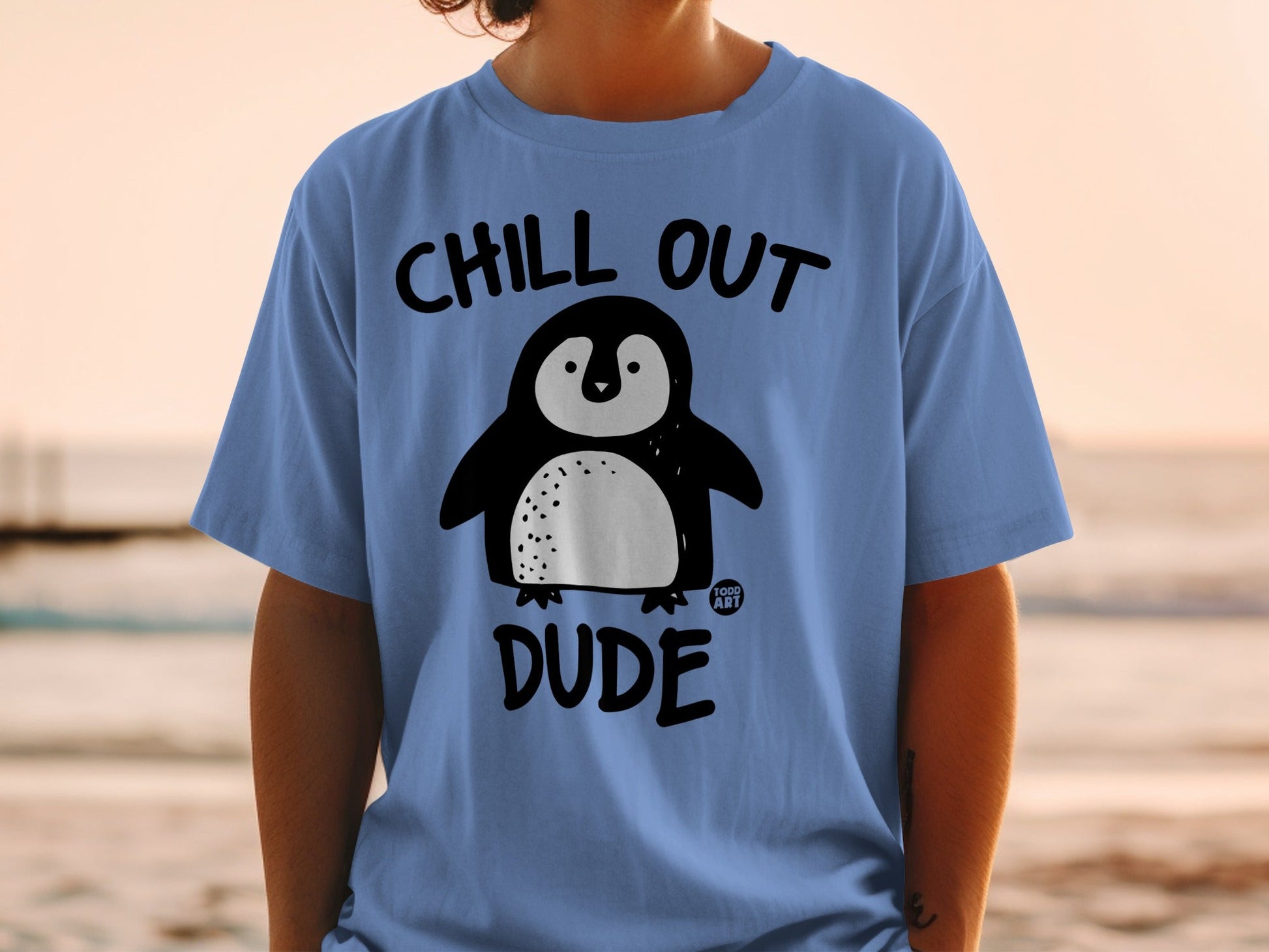 Blue t-shirt with cartoon penguin and "CHILL OUT DUDE" text.