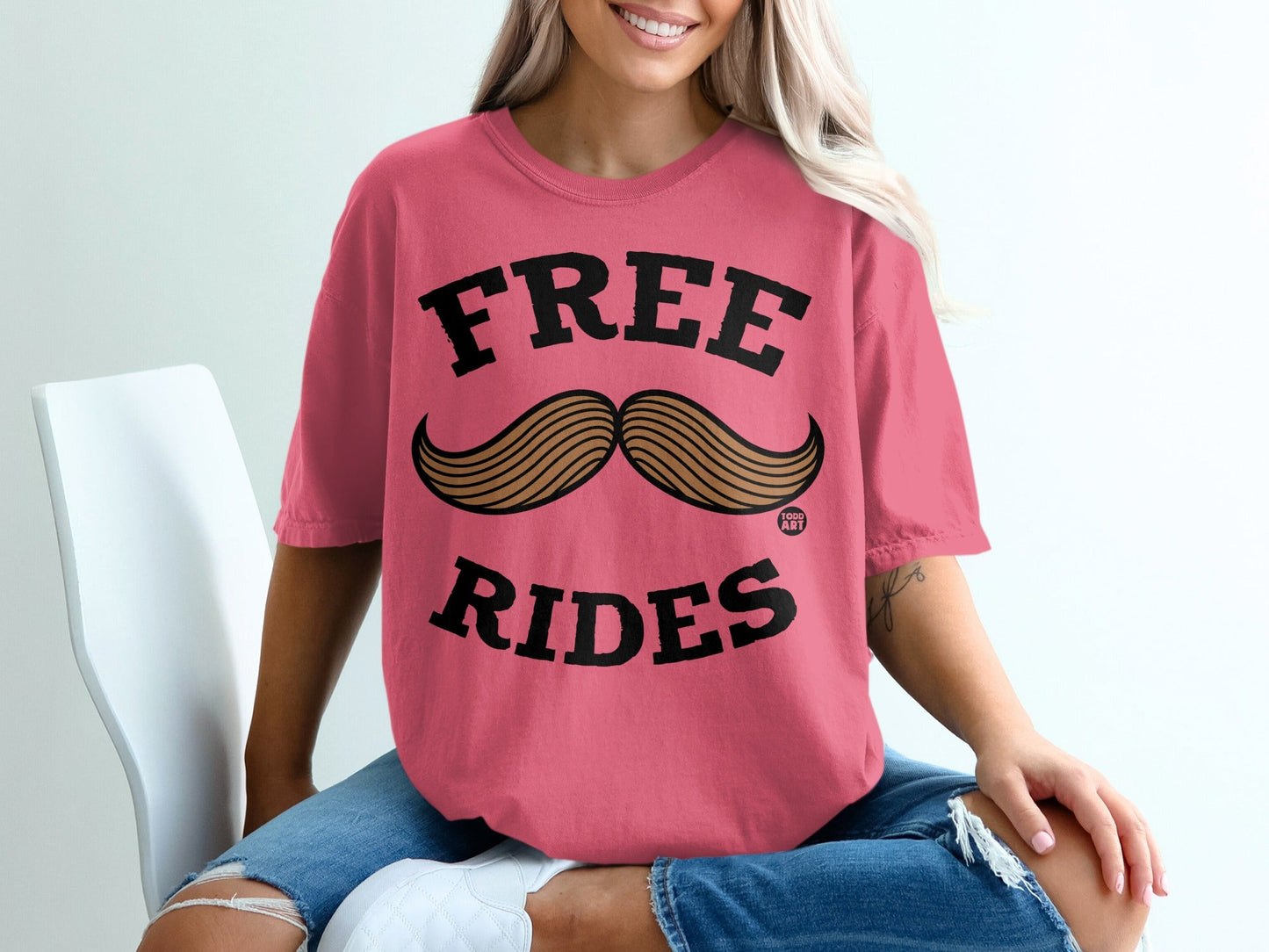 Pink t-shirt with "FREE RIDES" and a mustache graphic.