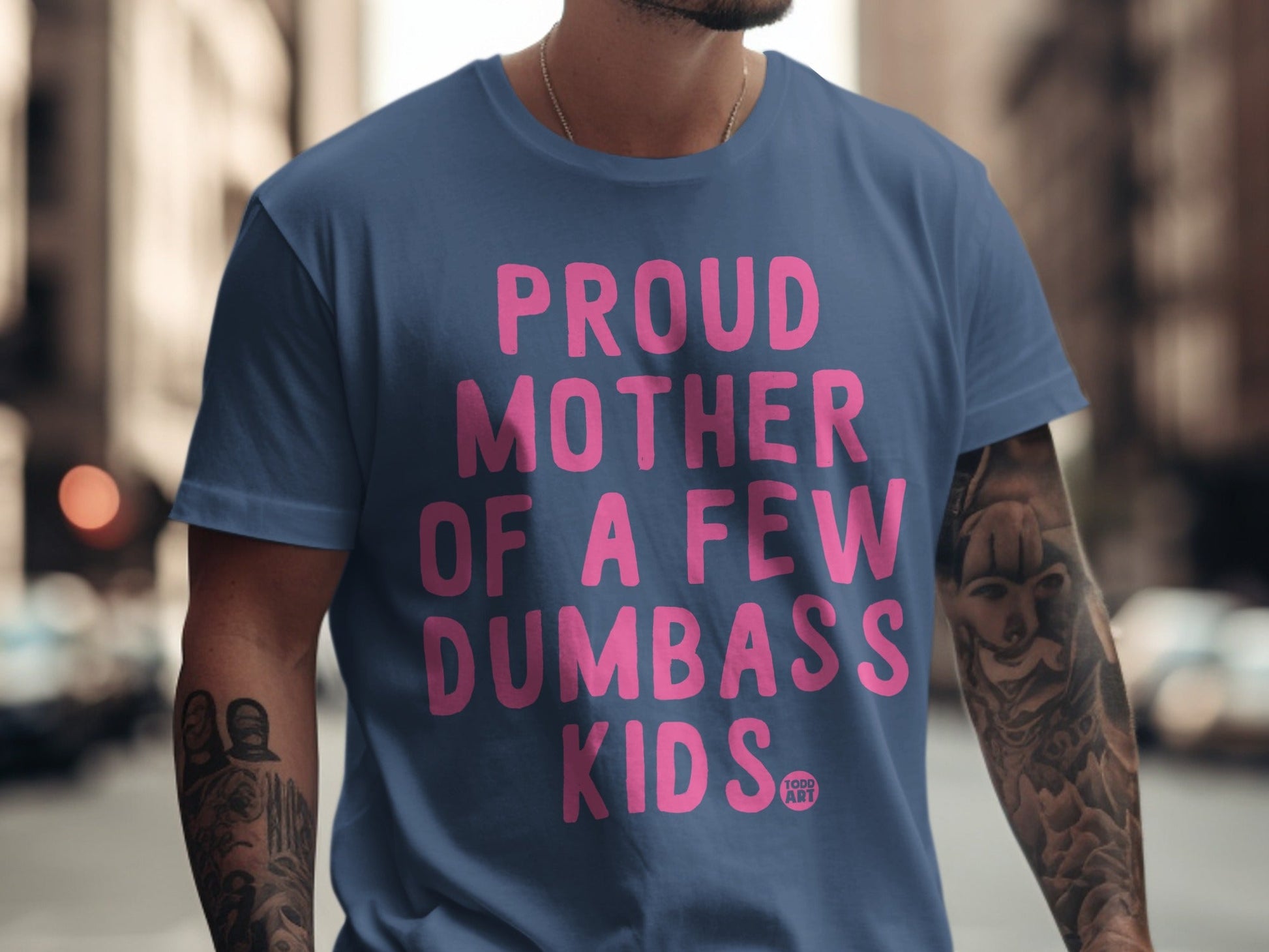 Blue t-shirt with pink text: "PROUD MOTHER OF A FEW DUMBASS KIDS."