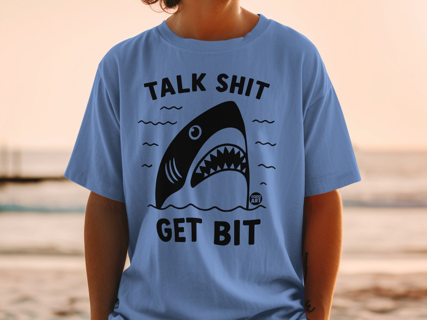 Blue t-shirt with shark graphic and "Talk Shit Get Bit" text.
