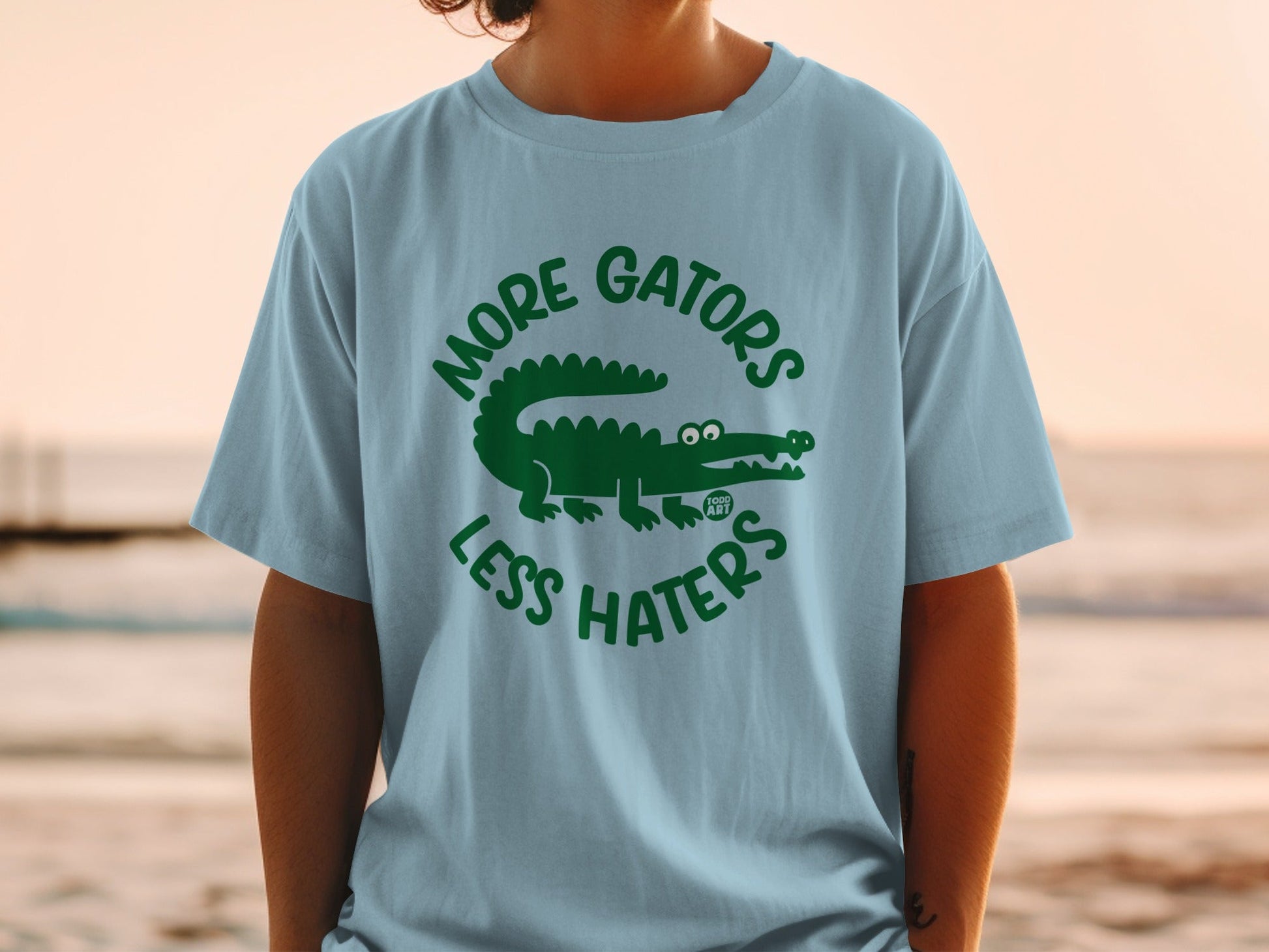 Light blue t-shirt with green "More Gators Less Haters" text and alligator graphic.