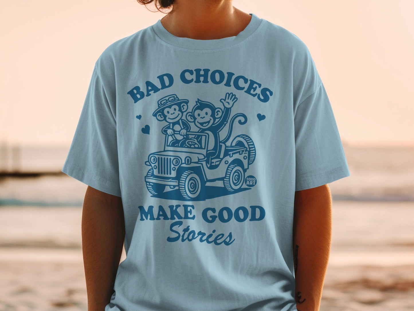 T-shirt with cartoon monkeys in a jeep and text "BAD CHOICES MAKE GOOD STORIES".