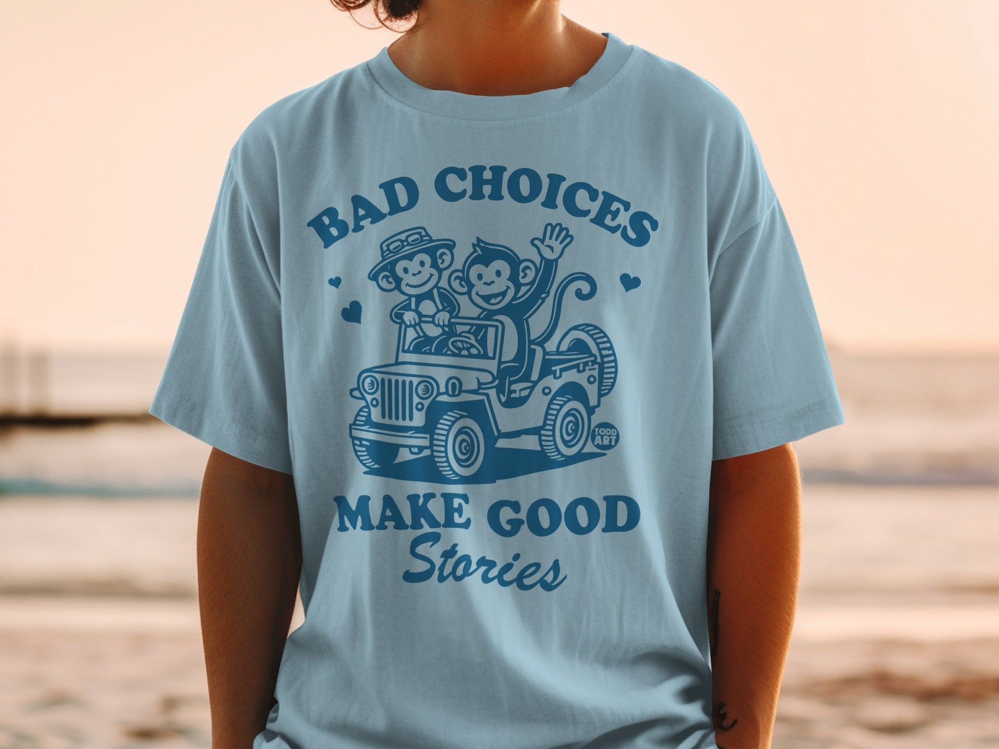 T-shirt with cartoon monkeys in a jeep and text "BAD CHOICES MAKE GOOD STORIES".