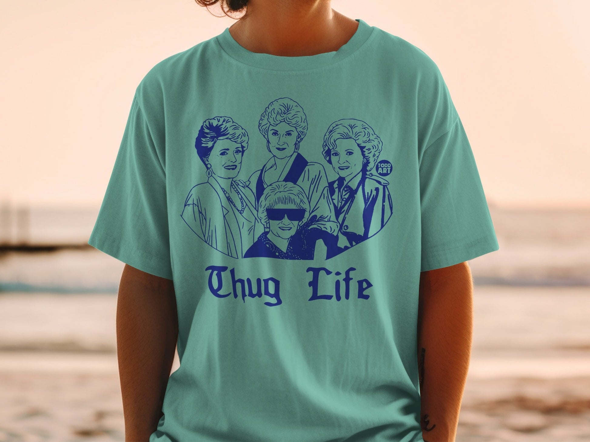 Blue t-shirt with a graphic of The Golden Girls with "Thug Life" text.