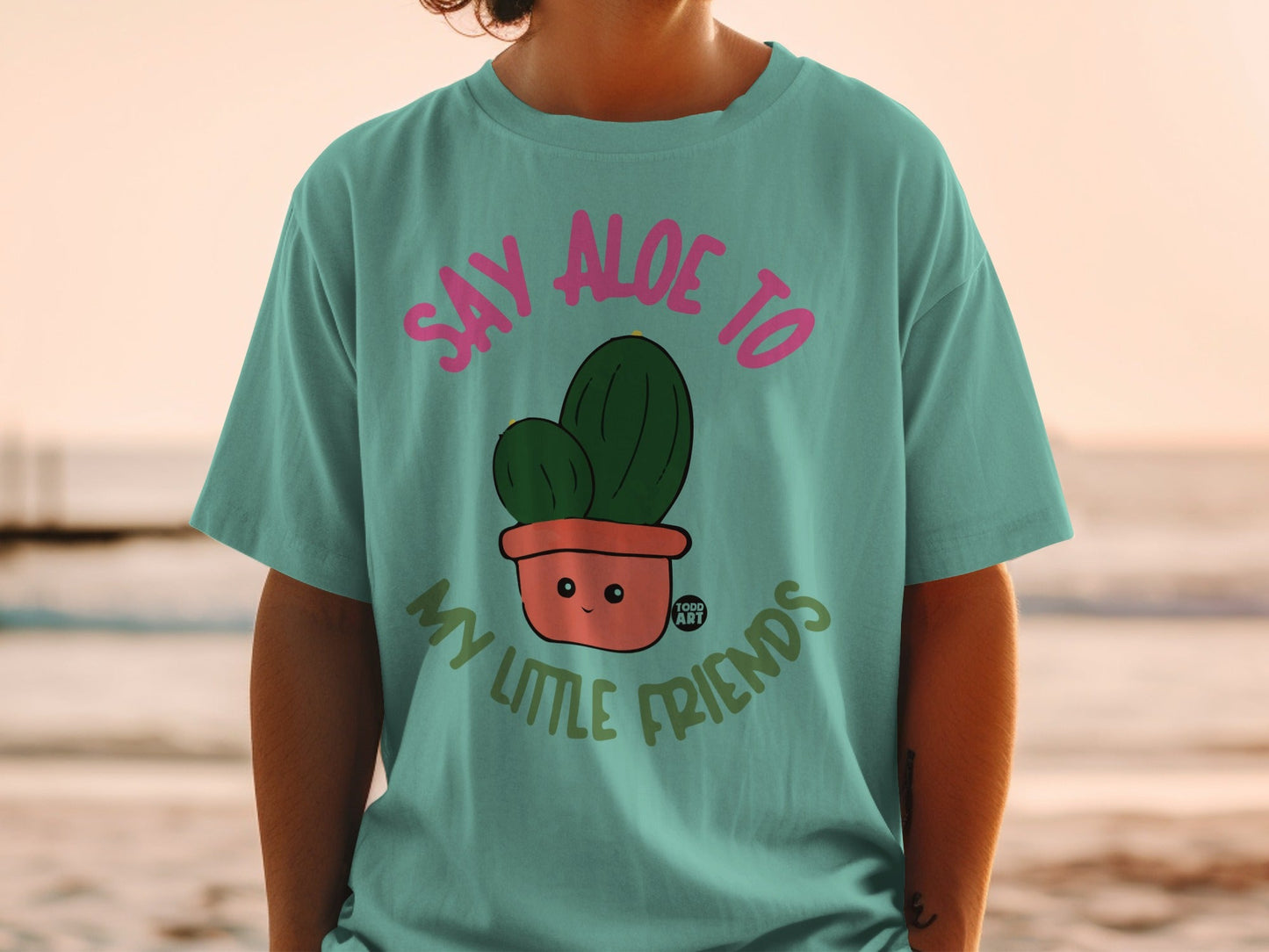 Teal t-shirt with cartoon cactus in pot that says "Say Aloe to My Little Friends".