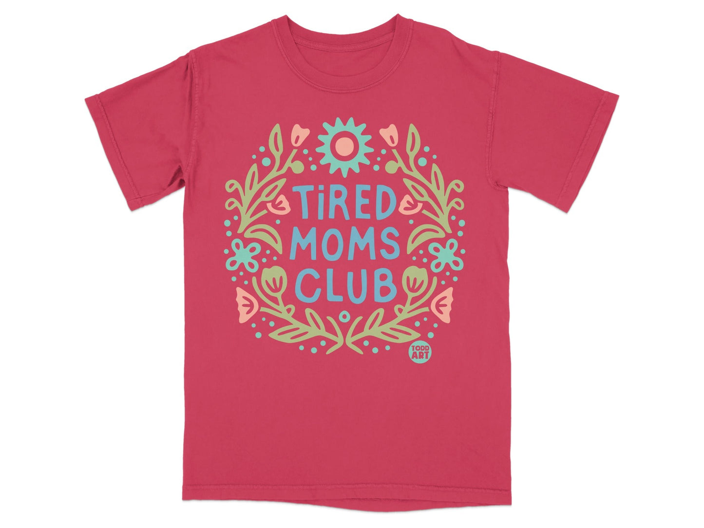 Pink t-shirt with "Tired Moms Club" text in a floral wreath design.