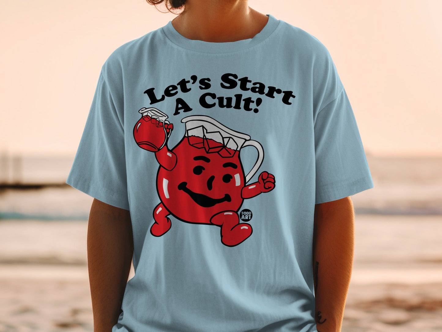 Light blue t-shirt with "Let's Start A Cult!" and Kool-Aid Man graphic.