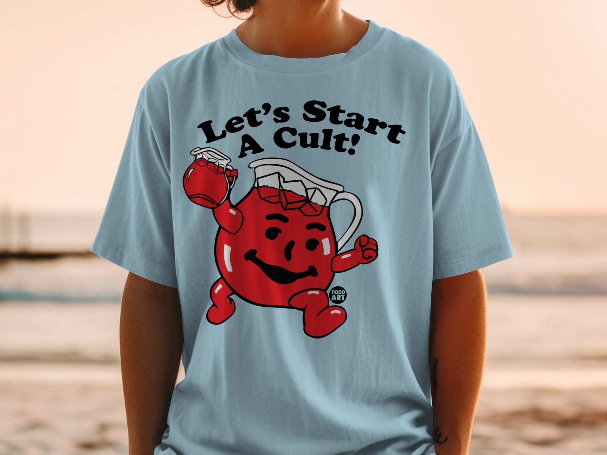 Light blue t-shirt with "Let's Start A Cult!" and Kool-Aid Man graphic.
