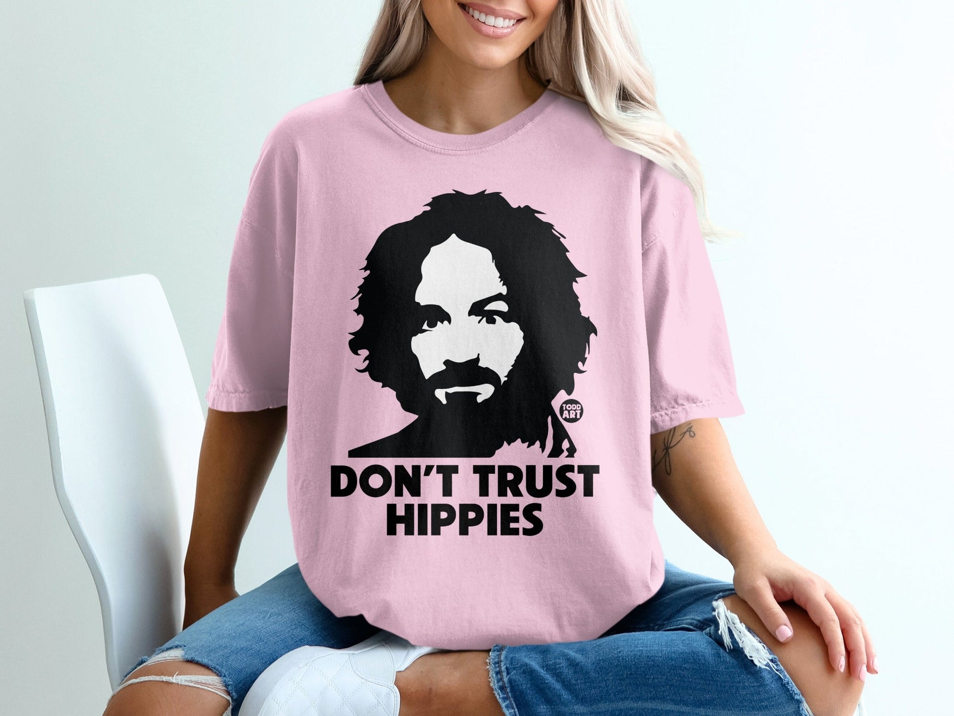 Pink t-shirt with Charles Manson graphic and text "DON'T TRUST HIPPIES."