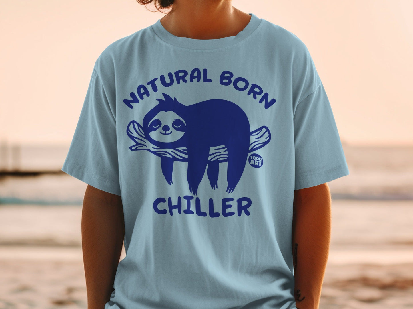 Light blue t-shirt with blue text "NATURAL BORN CHILLER" and a sloth graphic.