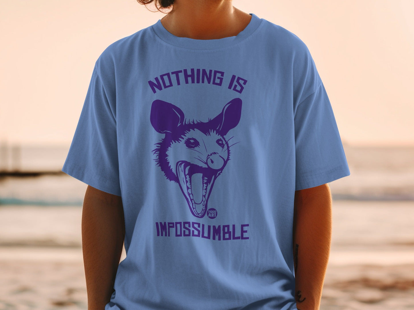 Purple t-shirt with a screaming opossum and text "NOTHING IS IMPOSSUMBLE".