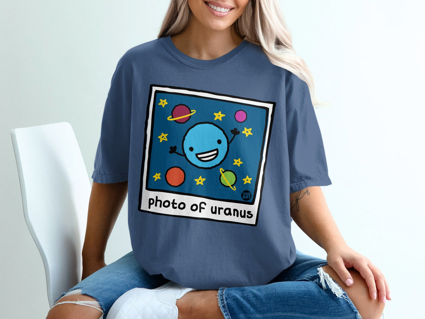 Blue t-shirt with cartoon planet and stars graphic reading "photo of uranus."