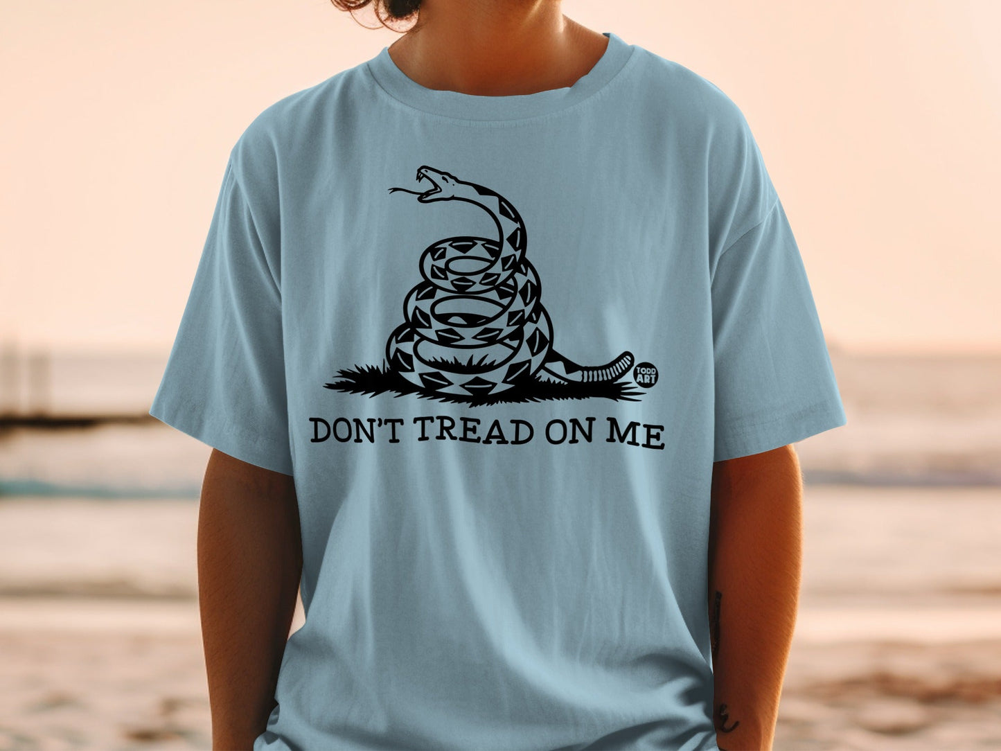 Light blue t-shirt featuring a coiled rattlesnake and "Don't Tread On Me" text.