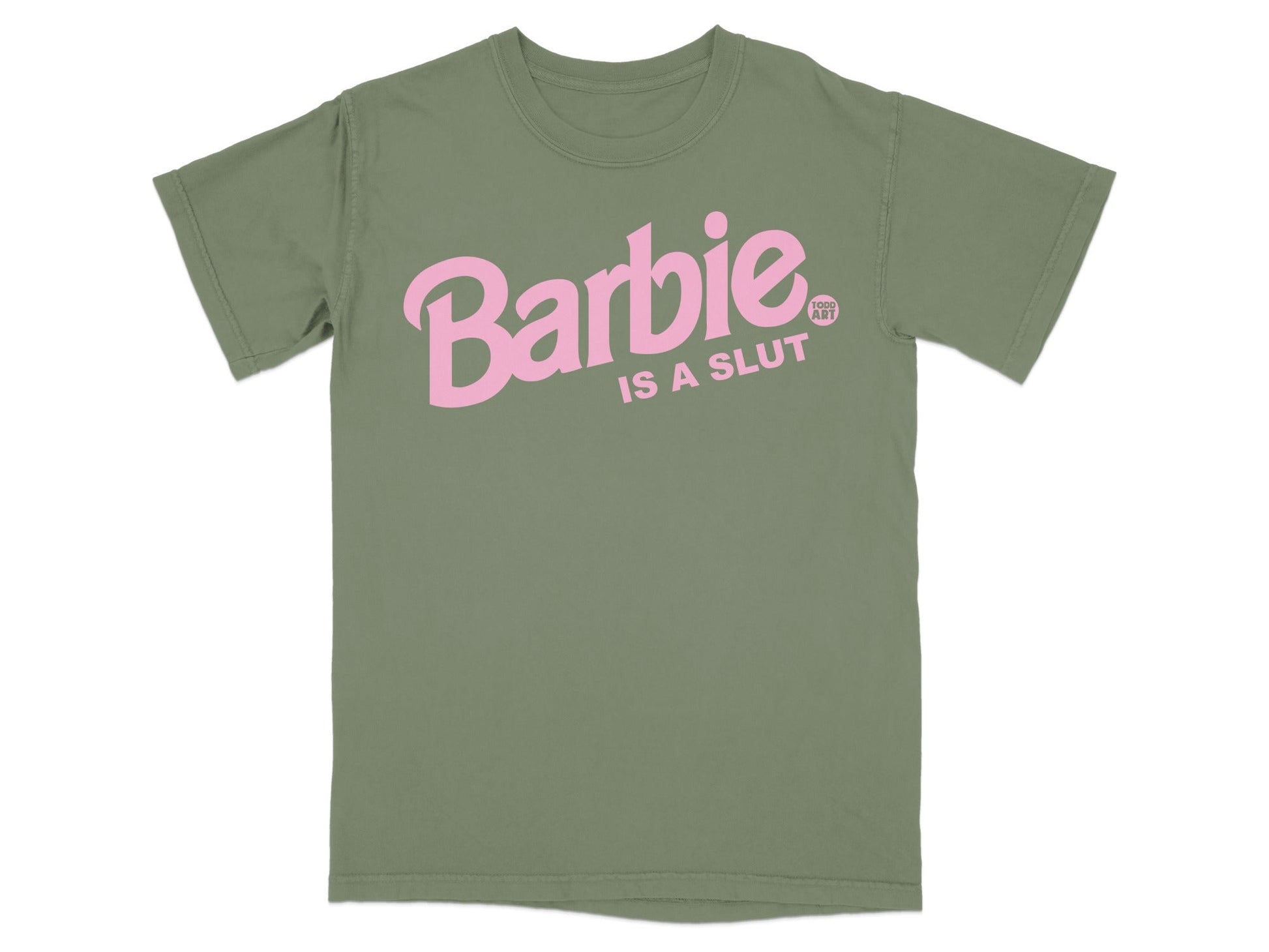 Olive green t-shirt with pink text reading "Barbie IS A SLUT" and a small "KINK ART" logo.