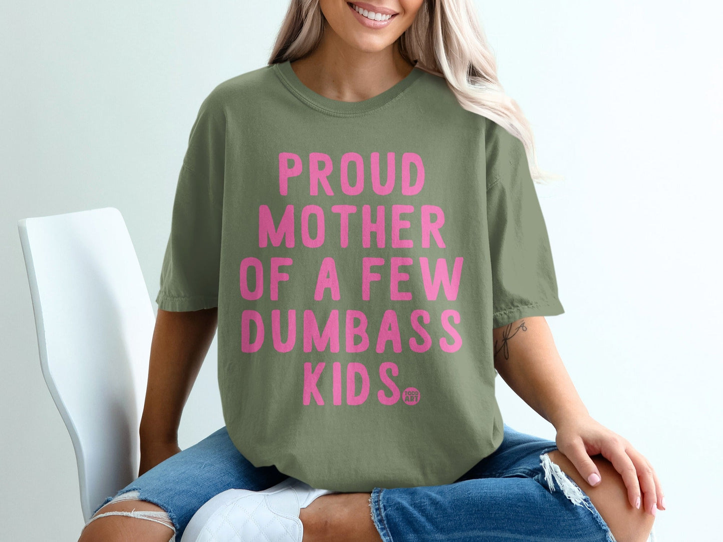 Olive green t-shirt with pink text that reads "Proud mother of a few dumbass kids".