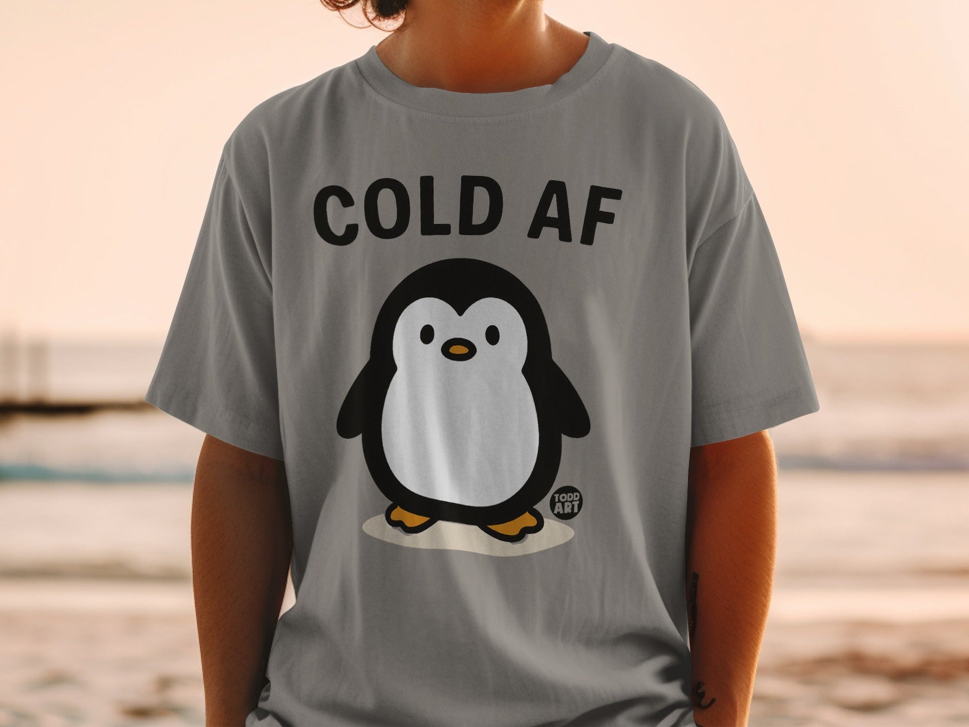 Gray t-shirt with a cartoon penguin and "COLD AF" text.