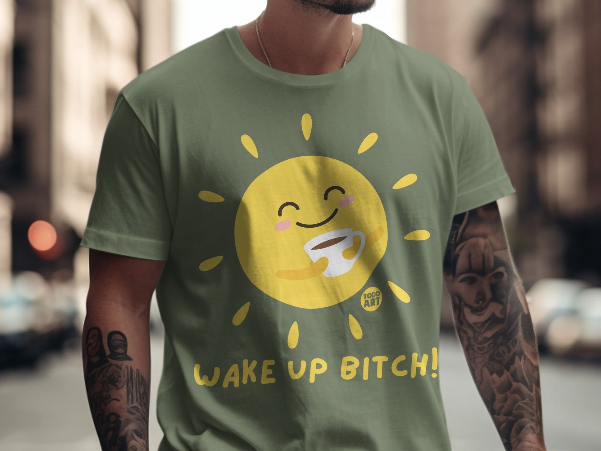 Olive green t-shirt with cartoon sun holding coffee and "Wake Up Bitch!" text.