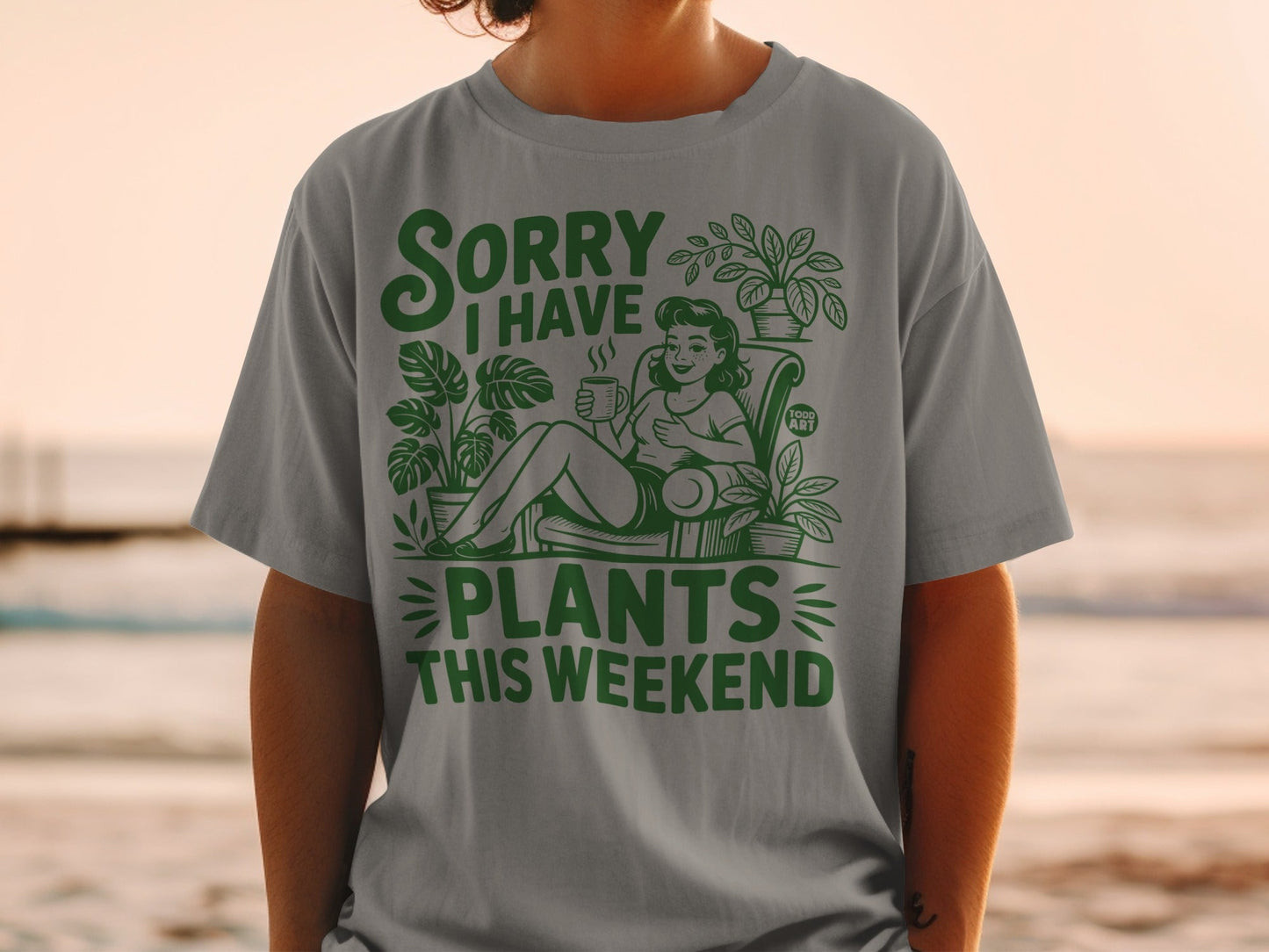 Green t-shirt with text "Sorry I Have Plants This Weekend" and potted plants.