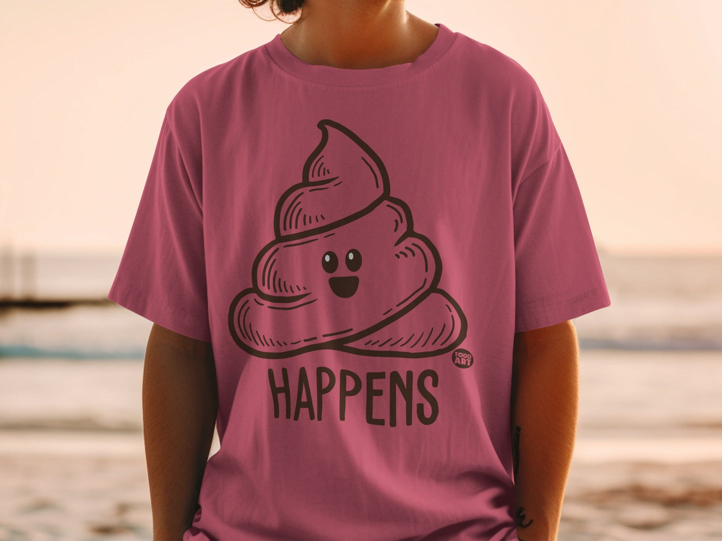 Pink t-shirt with a smiling pile of cartoon poop and the text "SHIT HAPPENS".