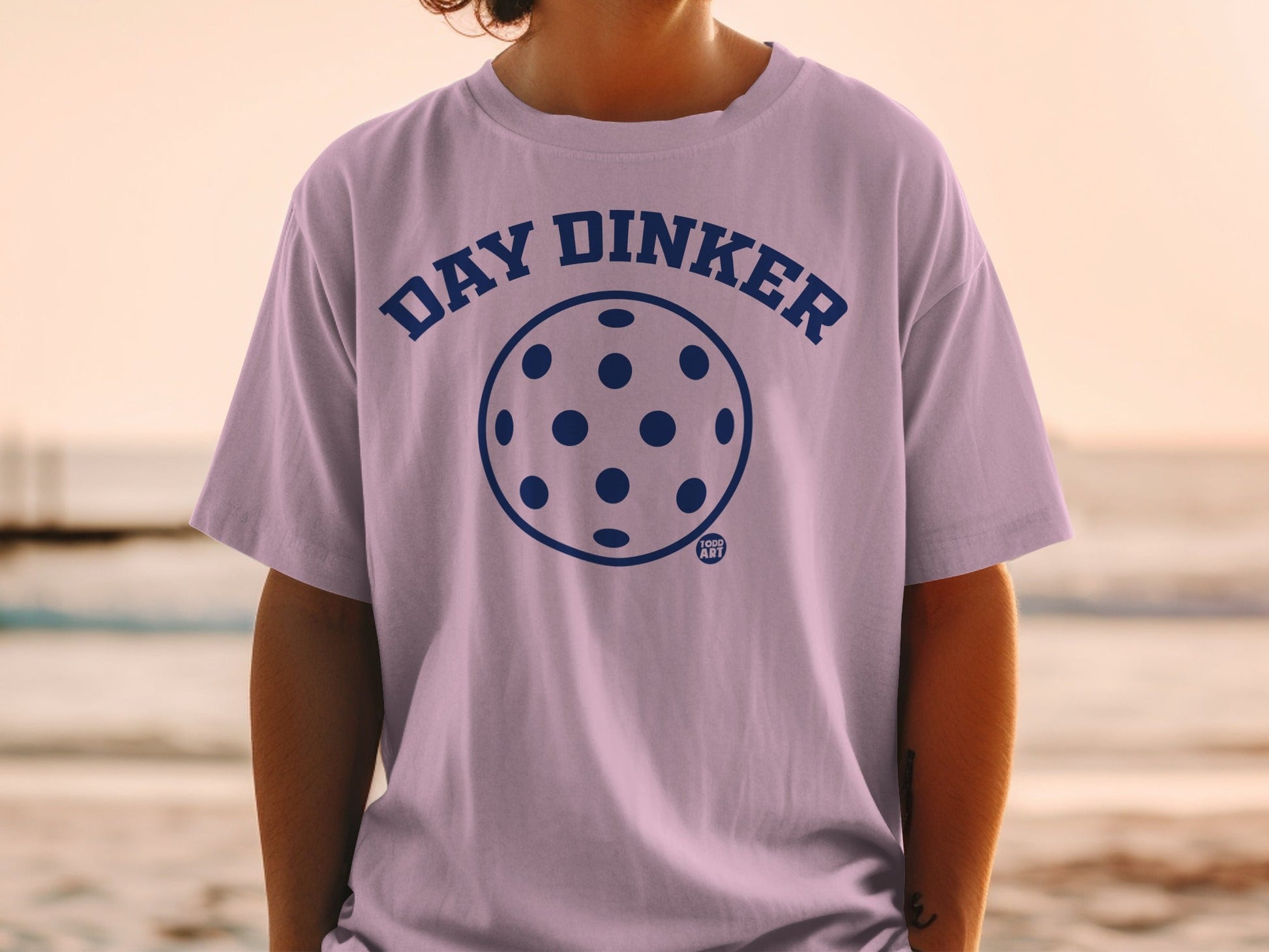 Purple t-shirt with "Day Dinker" text and pickleball graphic.