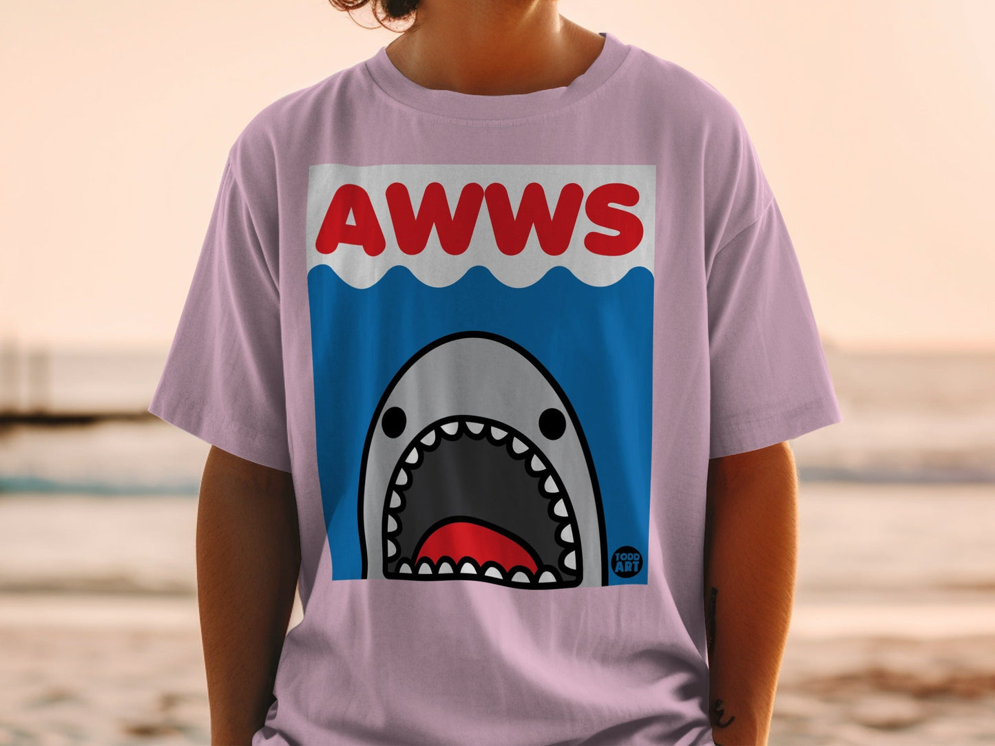 Pink t-shirt with a cartoon shark and "AWWS" text.