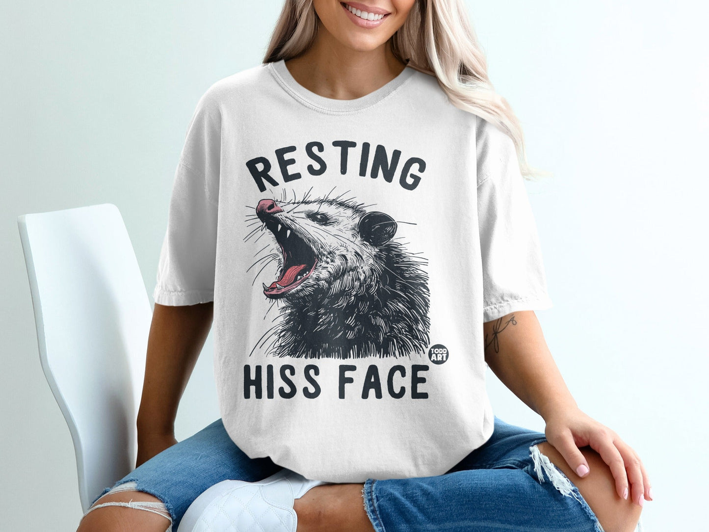 White t-shirt with black text "RESTING HISS FACE" and a graphic of an open-mouthed possum.