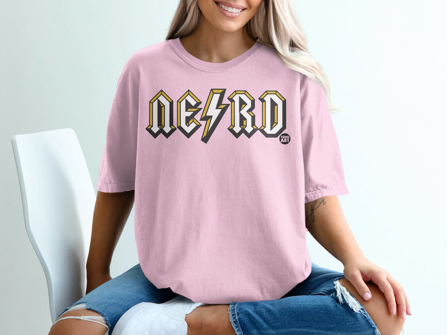 Pink t-shirt with "NERD" in yellow lightning bolt font and "GOOD ART" logo.