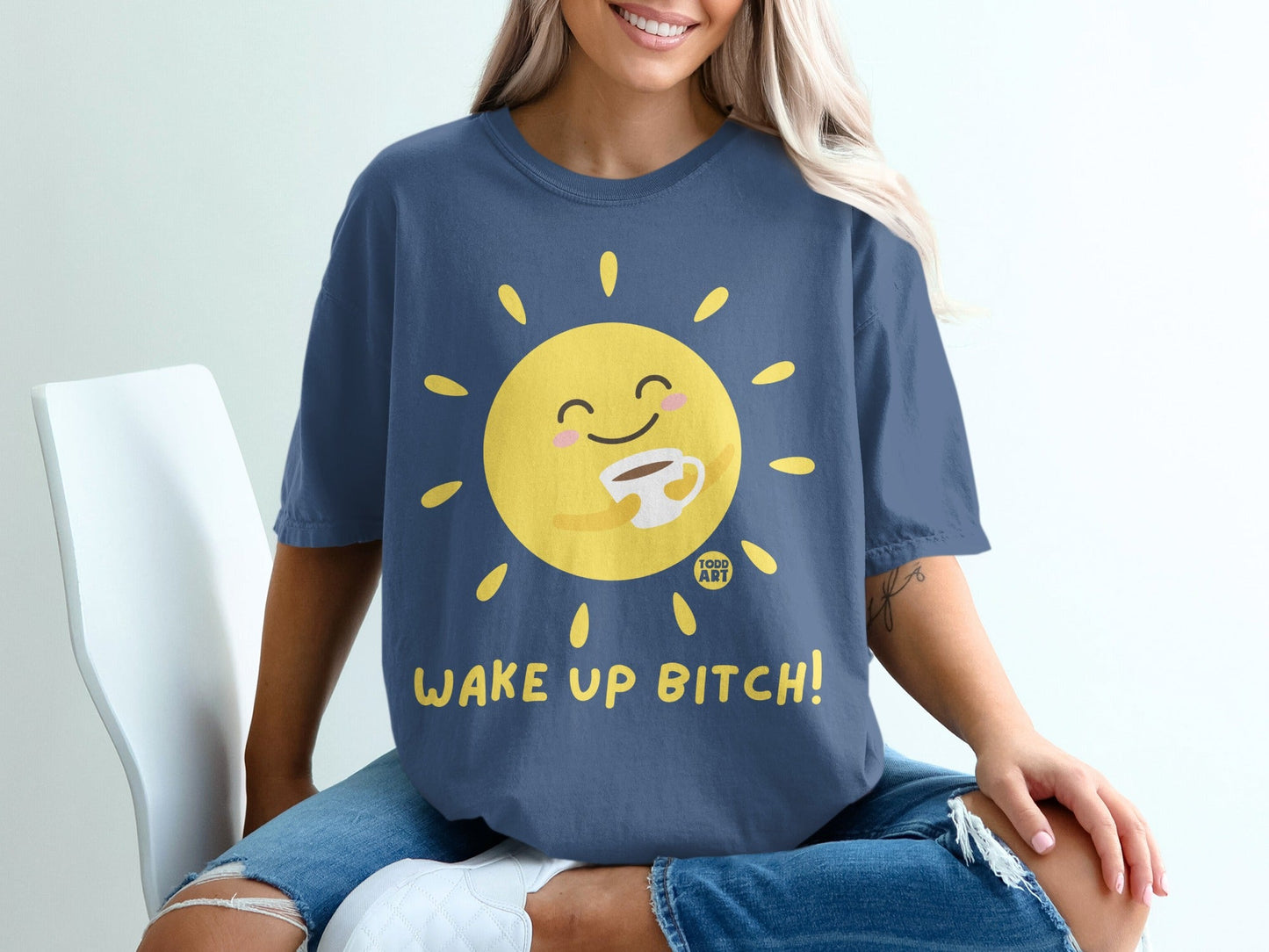 Dark blue t-shirt with a smiling sun holding coffee and text "WAKE UP BITCH!".