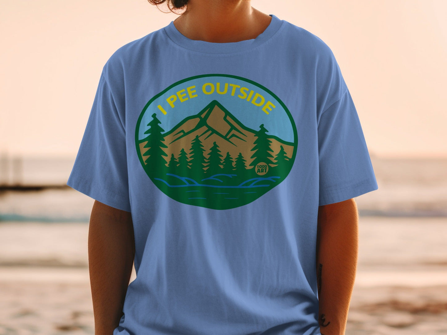 T-shirt with oval graphic of mountains, trees, and water with "I PEE OUTSIDE" text.