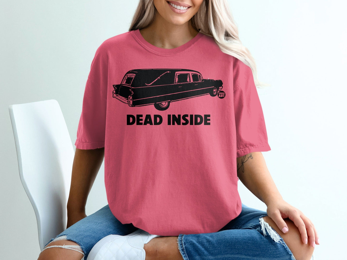 Pink t-shirt with black hearse graphic and "DEAD INSIDE" text.