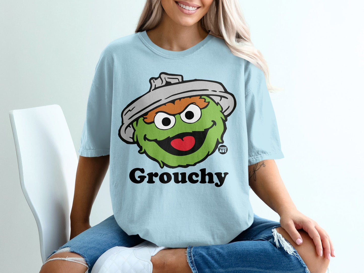 Light blue t-shirt with a cartoon Oscar the Grouch character and "Grouchy" text.